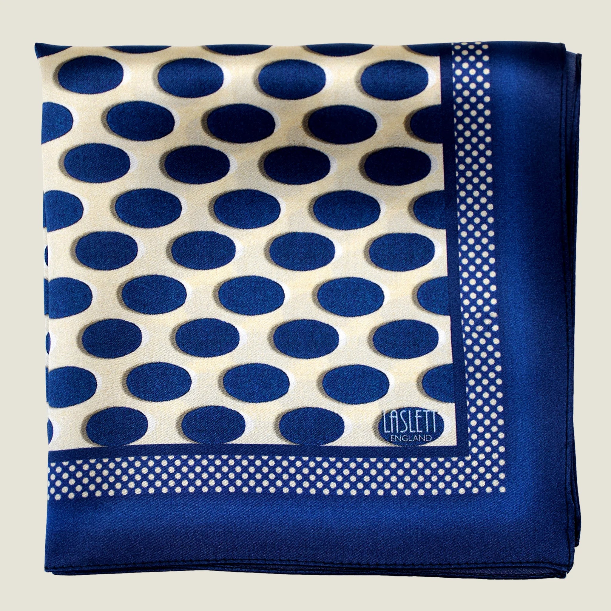 Laslett England Oval Spot Navy pocket square flat lay, showing large oval spot print in navy on cream silk with border detail