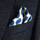 Laslett England Oval Spot Navy pocket square in breast pocket of dark suit, cream silk with large navy oval spot print