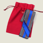 100% silk Dogtooth Blue Laslett Ribbon in black and blue by Laslett England. Ribbon is pictured on top of the red Laslett England presentation pouch. 
