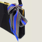 100% silk Dogtooth Blue Laslett Ribbon in black and blue by Laslett England. Ribbon is tied in a bow around the handle of a black handbag. 
