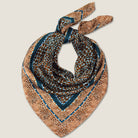 Laslett England silk scarf folded into triangle, showing teal border and bronze animal print edges.