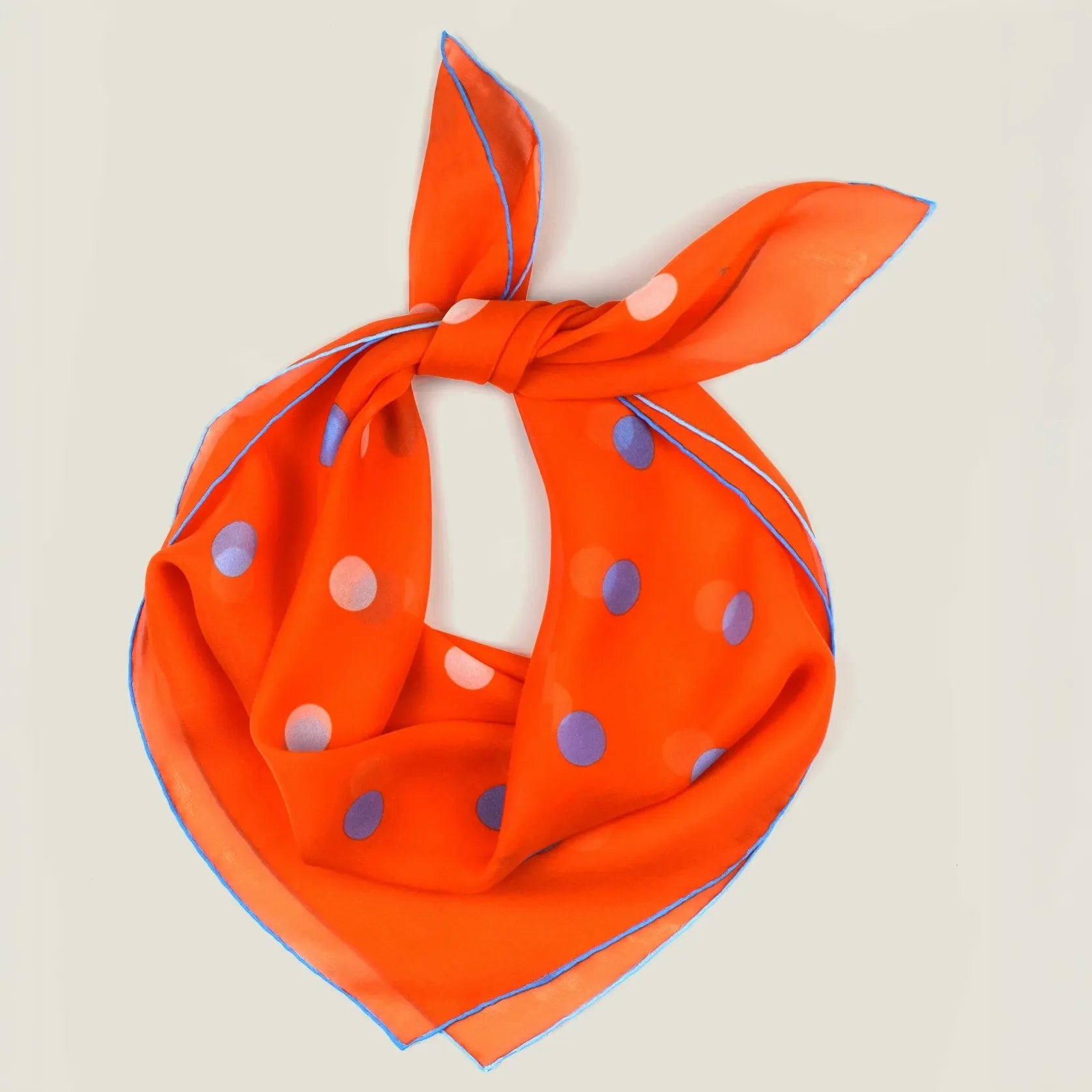 100% silk Solitaire Spot Orange Chiffon in orange by Laslett England. Product shot of scarf tied behind the neck. 