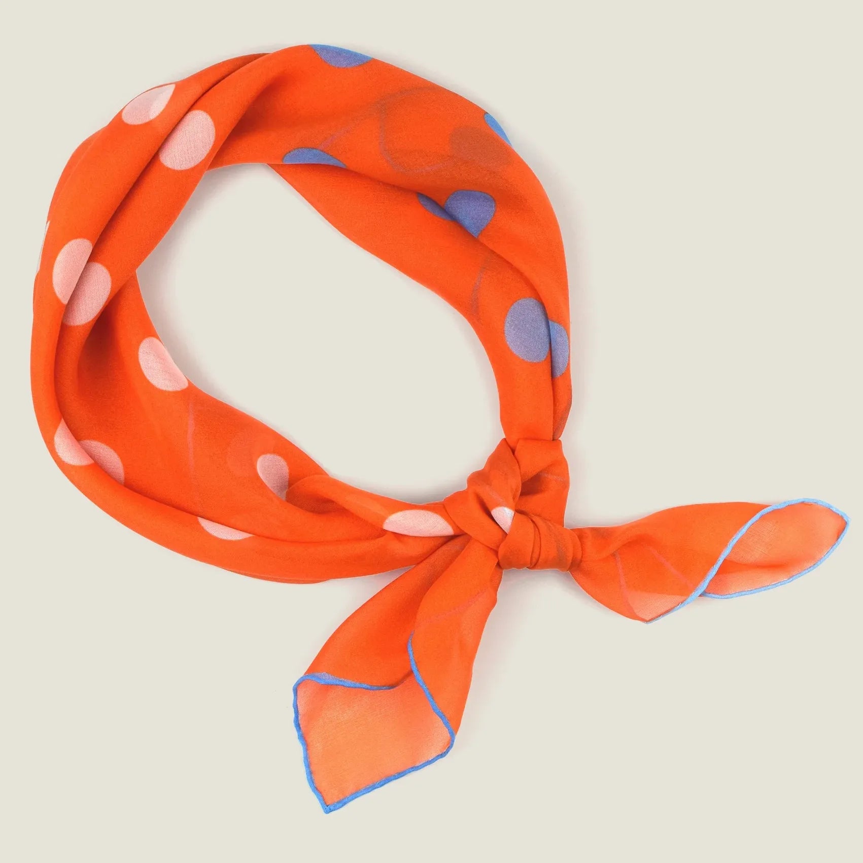 100% silk Solitaire Spot Orange Chiffon in orange by Laslett England. Product shot of scarf tied in front. 