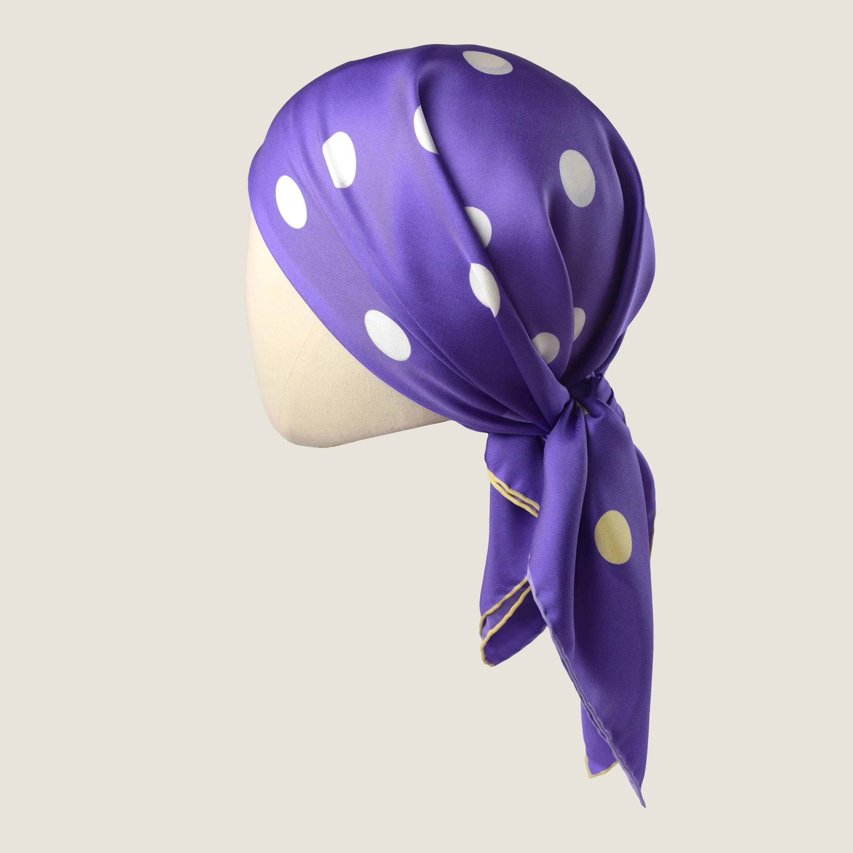 Laslett England Solitaire Violet Foulard knotted as a head covering, violet silk satin with lemon polka dots.
