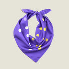Laslett England Solitaire Violet Foulard folded into triangle, showing violet silk satin with lemon and cream polka dots and cream hand-rolled edge. 