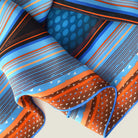 100% silk Sunset Orange Laslett Diamond in orange and blue by Laslett England. Scarf show in close-up folded over to display the pattern. 