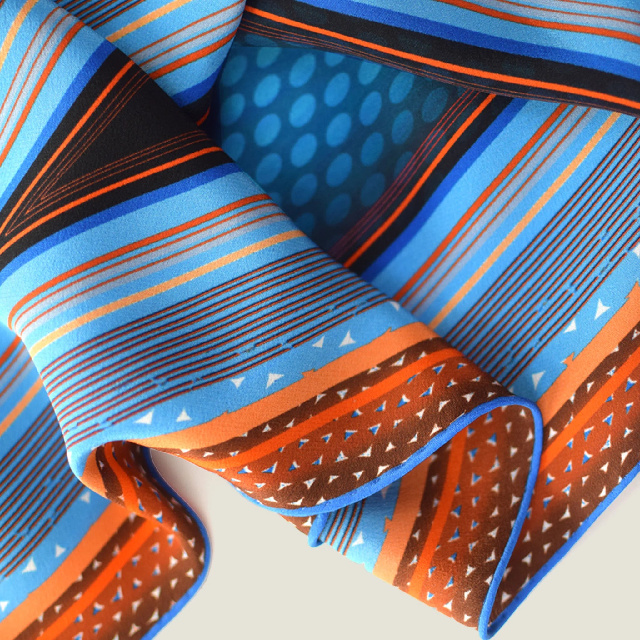 100% silk Sunset Orange Laslett Diamond in orange and blue by Laslett England. Scarf show in close-up folded over to display the pattern. 