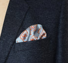 Laslett England Tapestry Rose silk pocket square in breast pocket of grey suit jacket, blue and terracotta print.