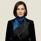 Female model wears a black velvet suit and the Tuxedo Blue Laslett England silk scarf showing contrasting patterns. 