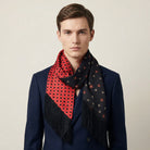 Laslett England Tuxedo Red Fringed Silk Scarf worn at neck by male model in navy suit, red side facing outward with black tassel fringe hanging down.
