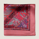 Laslett England Marble Red pocket square with red marbled interior and geometric edge pictured folded in four on flat lay.