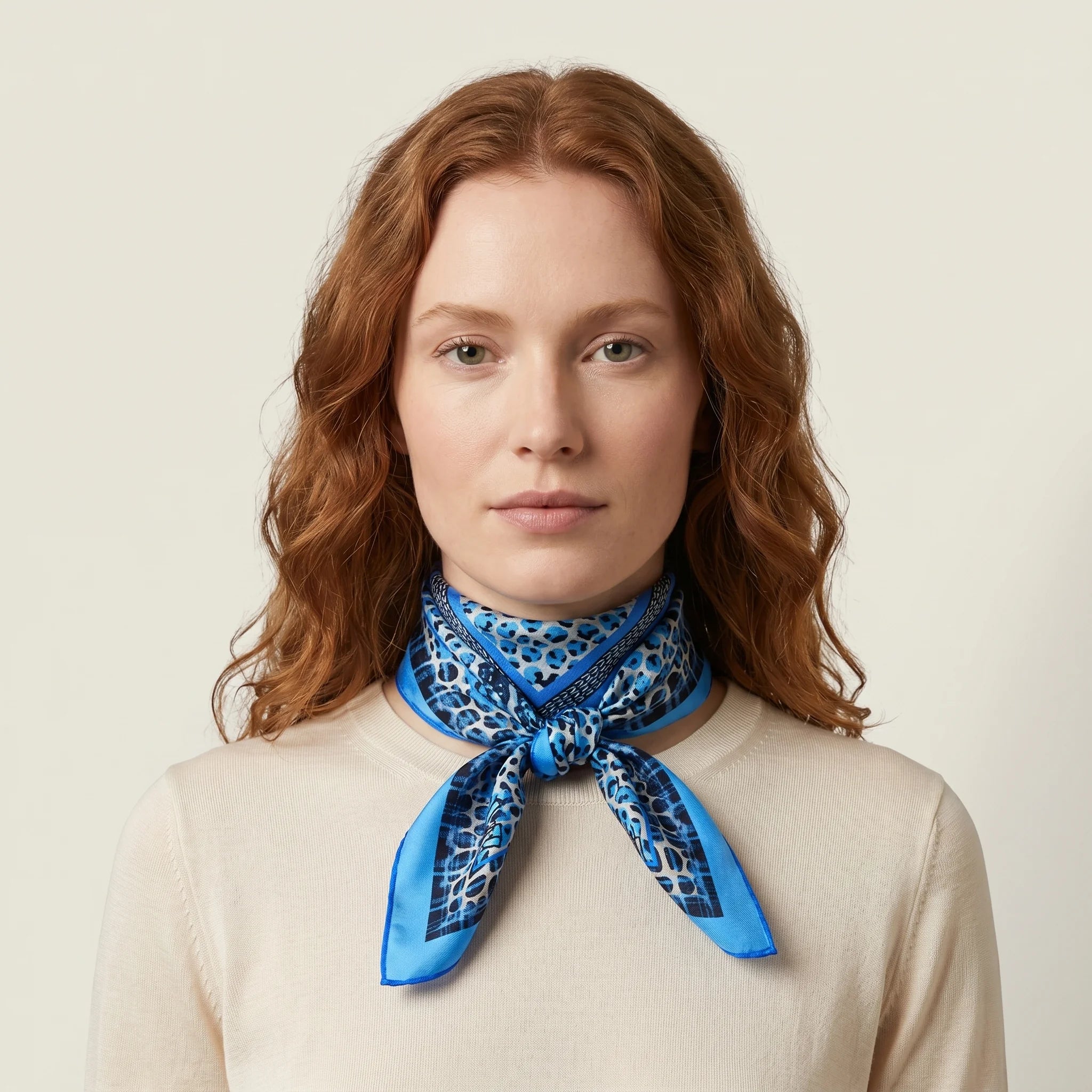 100% silk Tiger Moth Silk Bandana in blue with animal print by Laslett England. Shown knotted in front on a model. 